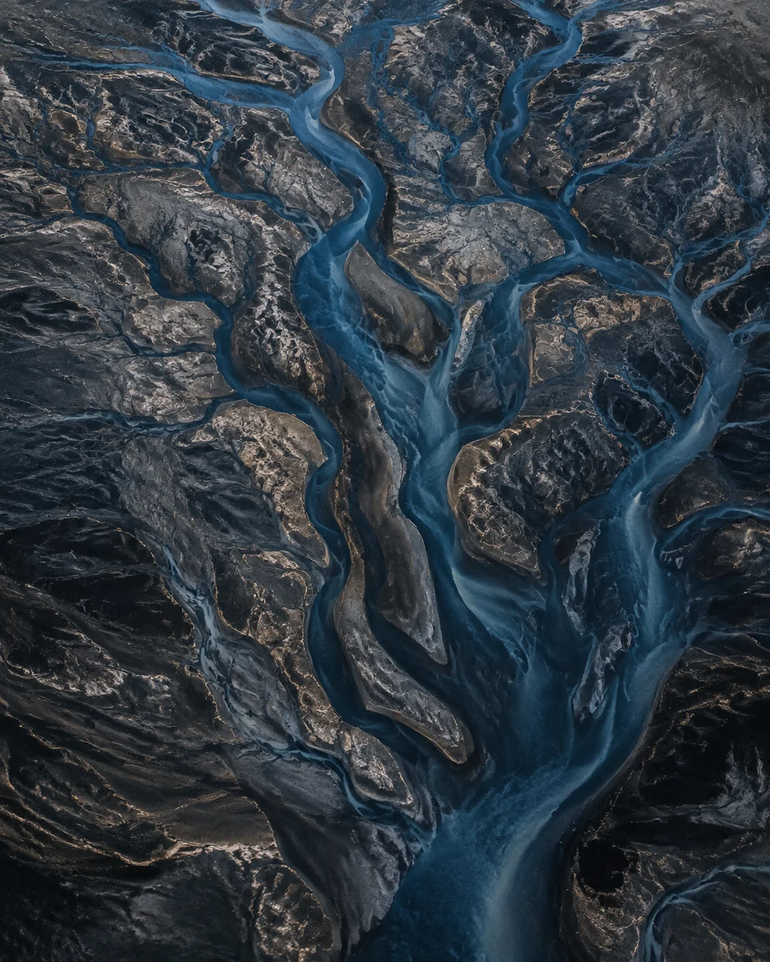 Illustrative aerial view of branching waterways joining a wider estuary.
